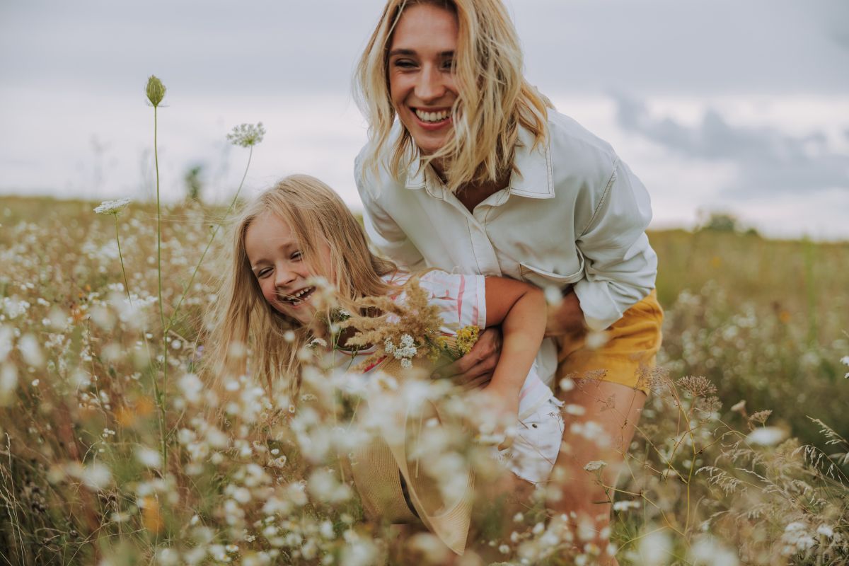 woman and child laughing in field